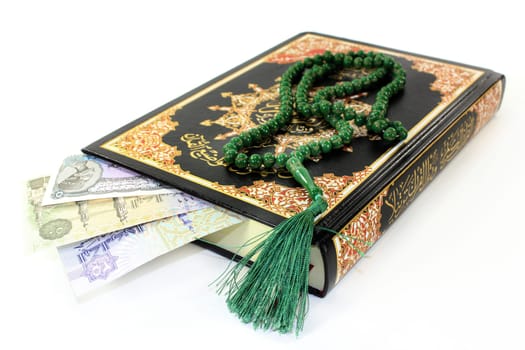 Quran with Egyptian banknotes against a white background