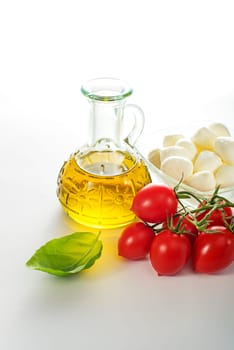 Fresh mozzarella cheese with tomato, basil and olive oil on white background
