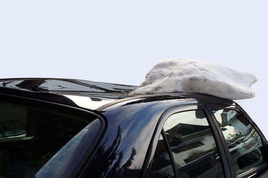 A roof avalanche has severely damaged a black car on the roof. Damage caused by a roof avalanche on a car