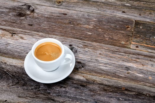 cup of coffee on wooden table from above