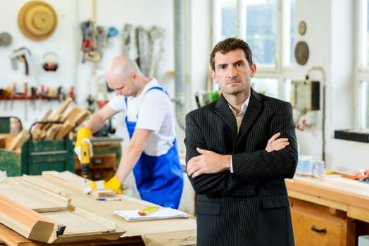 boss and worker together in a carpenter's workshop