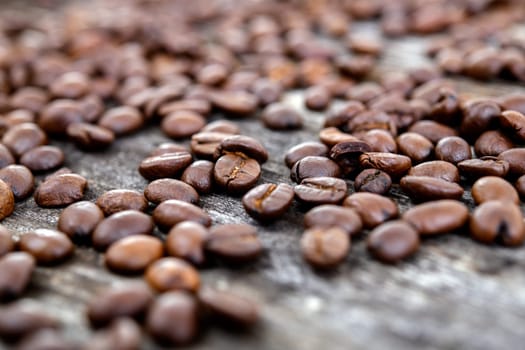 a lot of brown roasted coffee beans on wooden ground