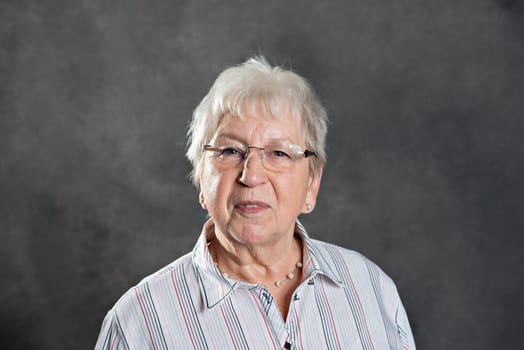 gray hairy elderly woman looking friendly
