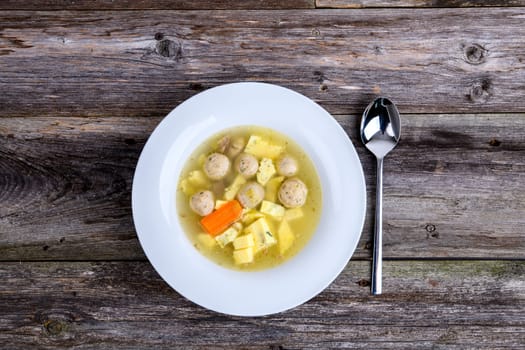 marrow balls soup in white plate on wooden ground