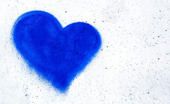 Blue heart shaped on grungy wall background with copy space