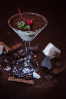 Ice cream chocolate dessert decorated with cherry on dark brown background