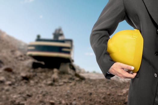 Contractor man holding a yellow helmet on construction site