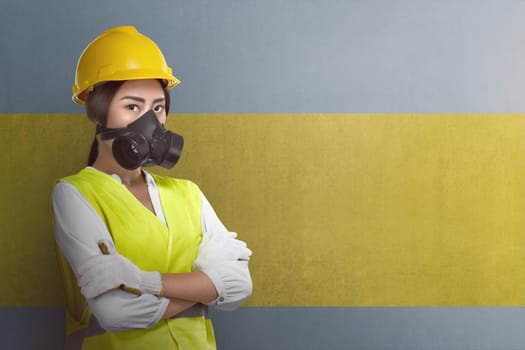Attractive asian worker woman with crossed arms standing on wall background