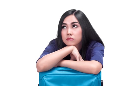 Portrait of sad asian woman with suitcase posing isolated over white background