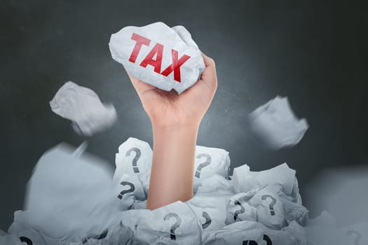 People hand holding paper with Tax sign over dark background