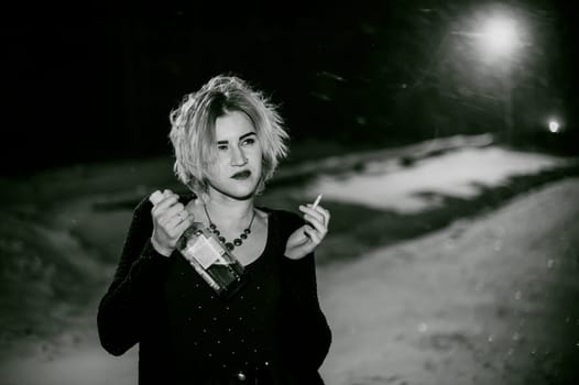 Black and white portrait of a girl with a cigarette. young beautiful woman with dyed hair smoking a cigarette in the street under the snow