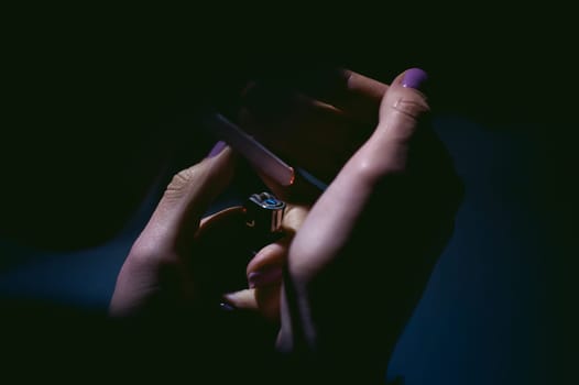 Portrait of a girl with a cigarette. young beautiful girl hipster with dyed hair smoking a cigarette in the street under the snow. her hands lights a lighter, lighting a cigarette tobacco