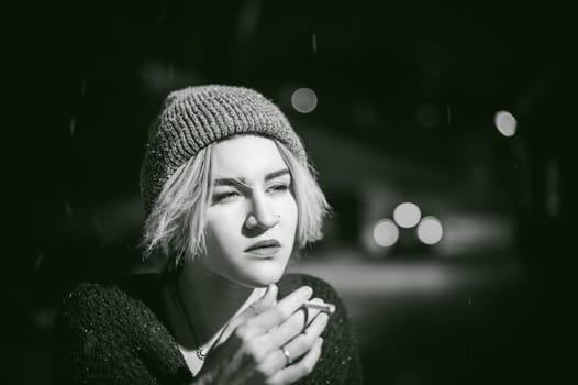Portrait of a girl with a cigarette. young beautiful girl with dyed hair hipster hat. cigarette smoking on the street under the snow