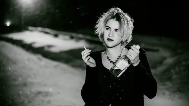 Black and white portrait of a girl with a cigarette. young beautiful woman with dyed hair smoking a cigarette in the street under the snow