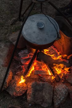 Preparing food on campfire in wild camping, resting on the nature