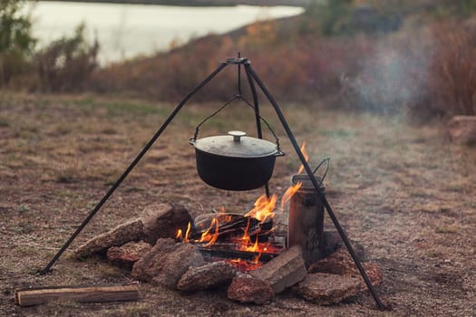 Preparing food on campfire in wild camping, resting on the nature