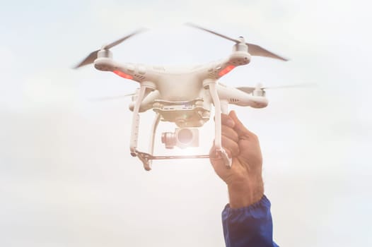 The flying drone copter with digital camera and human hand