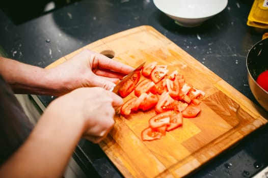 woman housewife in the kitchen. woman cuts vegetables, cooking, knife on a cutting board. Hands cooks close up