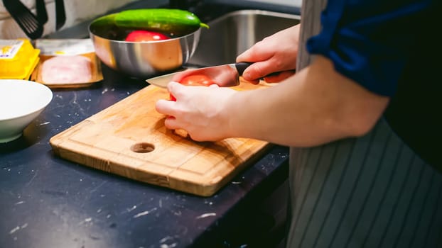 woman housewife in the kitchen. woman cuts vegetables, cooking, knife on a cutting board. Hands cooks close up