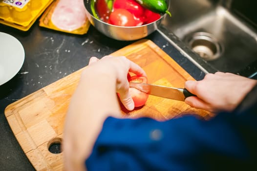woman housewife in the kitchen. woman cuts vegetables, cooking, knife on a cutting board. Hands cooks close up