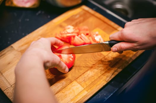 woman housewife in the kitchen. woman cuts vegetables, cooking, knife on a cutting board. Hands cooks close up