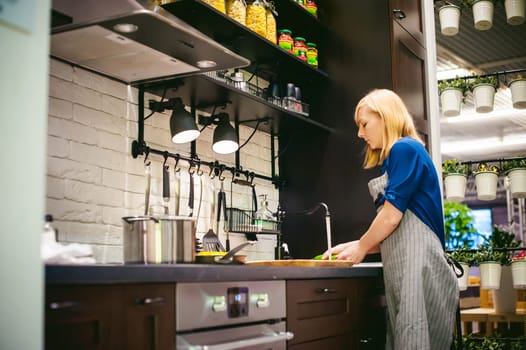woman washing vegetables for cooking, water under the tap