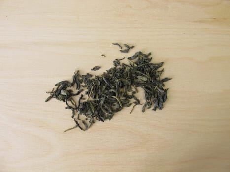 Green tea Chun Mee from China on a wooden board