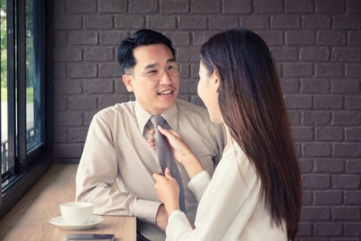 Woman help knot necktie of man, get ready to work in the morning, love couple concept