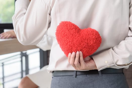 Man holding red heart behind his back to surprise woman, love and valentine concept