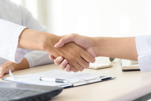Business people shaking hands after closing deal in office, partnership merger and acquisition concept