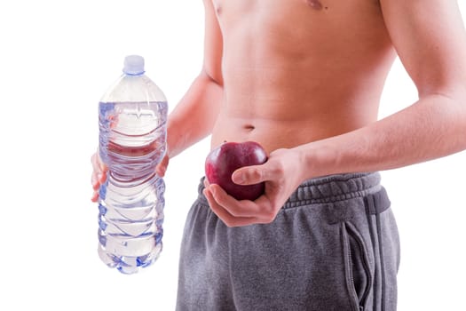 Young sporty man holding red apple and bottle of water. Sport or healthy life concept. White background with copy space.