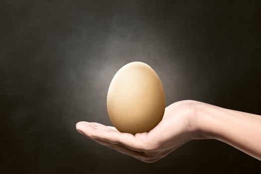 Image of people hand hold plain egg. Easter concept, you can design your own pattern at the egg