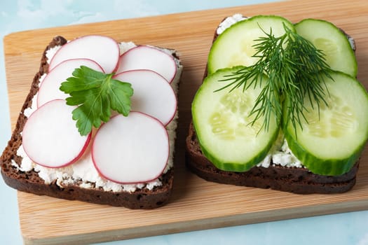Freshly prepared open-faced sandwiches with cucumbers and radishes.