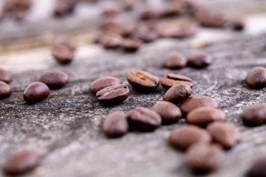 a lot of brown roasted coffee beans on wooden ground