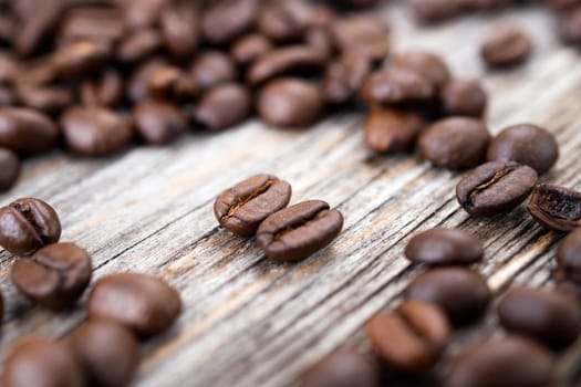 a lot of brown roasted coffee beans on wooden ground