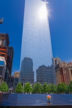 New York, USA - June 08, 2015: South pool memorial commemorating the victims of the 11 september terror attack in 2001. New York architecture in the background.