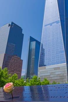 New York, USA - June 08, 2015: South pool memorial commemorating the victims of the 11 september terror attack in 2001. New York architecture in the background.