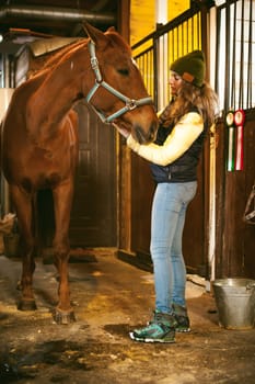 Female rider trains the horse out of the stables
