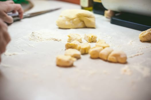 hand modeling dumplings at home in the kitchen. hands and the dough