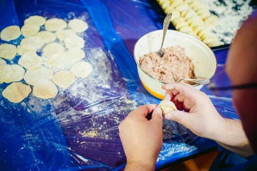 hand modeling dumplings at home in the kitchen.