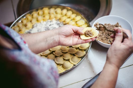 hand modeling dumplings at home in the kitchen.