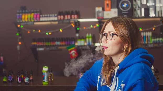 beautiful young woman with glasses smoking electronic cigarette