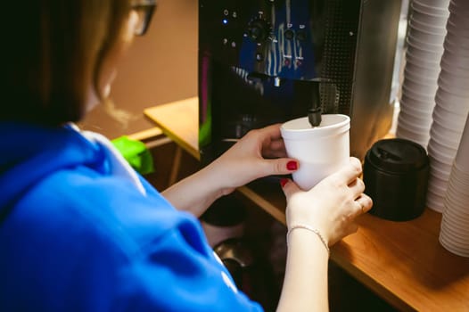 woman in cafe makes instant hot cocoa drink