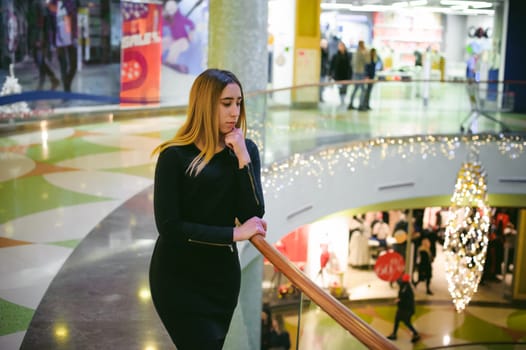 young woman in a black dress shopping mall