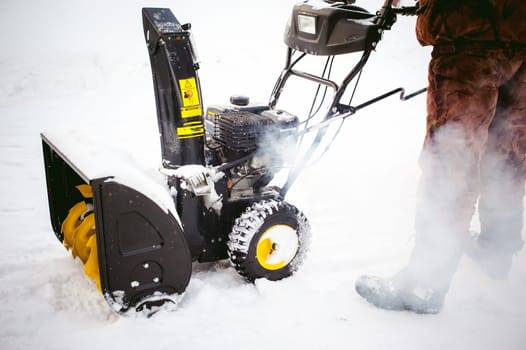 man starts the engine snow blower
