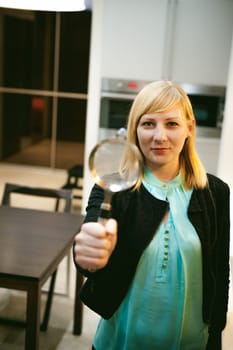 blonde woman in the kitchen, holding a cutlery