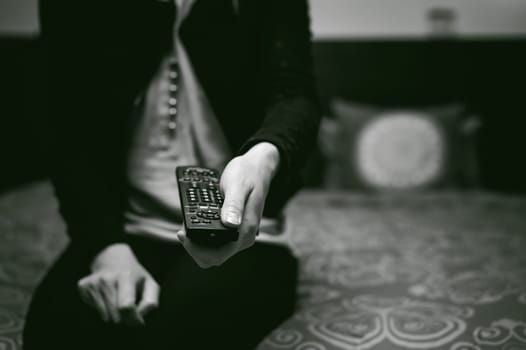 girl in a home environment, holding a TV remote, switching channels