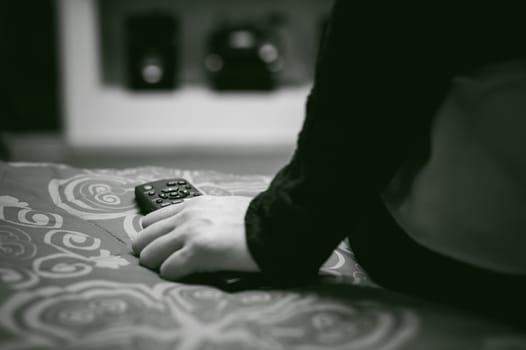 girl in a home environment, holding a TV remote, switching channels