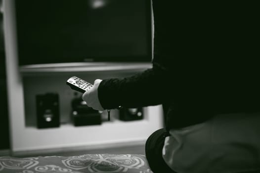 girl in a home environment, holding a TV remote, switching channels
