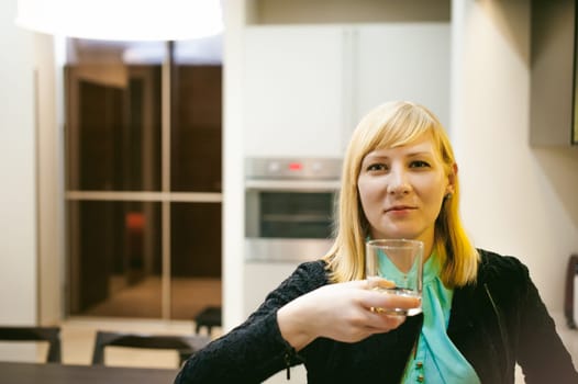 blonde woman in the kitchen, holding a cutlery